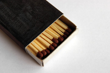 Wooden safety matchsticks stacked in cardboard matchbox.