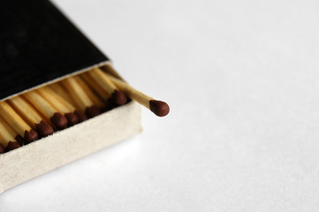 Wooden safety matchsticks stacked in cardboard matchbox.