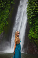 Fototapeta na wymiar beautiful girl walks near a waterfall