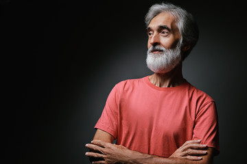 Studio portrait of handsome senior man with gray beard.