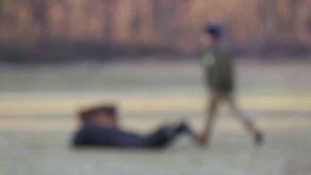 Blurred focus video footage. Soldiers training dog to attack in a field. Demonstration performance of police dogs, shepherd dogs, service dogs, service smart dogs, dog breeding, danger of attack.
