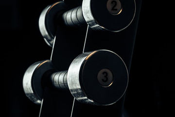 Sports equipment in gym. Dumbbells of different weight close up