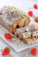 Tasty and fragrant cupcake with strawberries and almonds with a crispy crust on a white plate