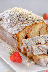 Tasty and fragrant cupcake with strawberries and almonds with a crispy crust on a white plate