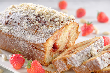 Tasty and fragrant cupcake with strawberries and almonds with a crispy crust on a white plate