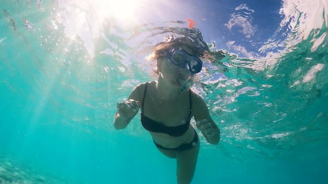 Young lady is swimming underwater in the sea