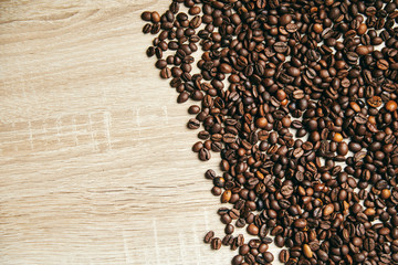 Coffee beans on the right side on wooden background