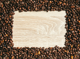 Frame of coffee beans on wood background, copy space