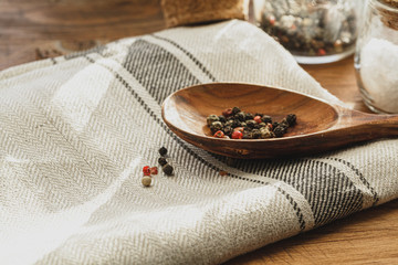 Striped linen napkin on wooden table with kitchen utensils close up