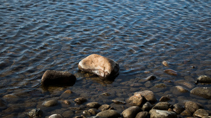 The pebble in the water. Stone background. Pebble.