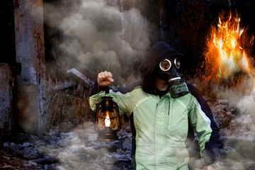 Art concept of the apocalypse - a man in a gas mask among smoke and fire.