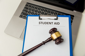 Document with student aid and wooden gavel on the table with laptop isolated