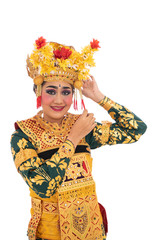 Balinese dancer woman standing with smile while fixing flower accessories on the crown