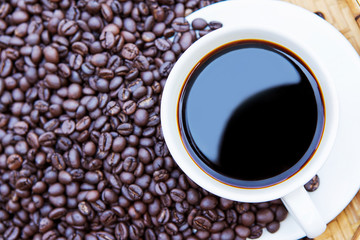 Coffee cup and coffee beans in a basket, Top view with copyspace for your text.