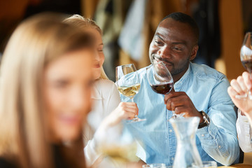 Afrikanischer Mann und Freundin stoßen an mit Wein