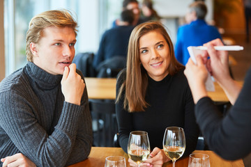 Mann mit Freundin gibt Bestellung auf im Bistro