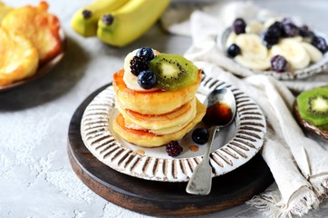 Fritters with honey, banana, blueberries and kiwi, breakfast