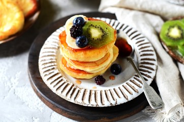 Fritters with honey, banana, blueberries and kiwi, breakfast