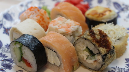 different types of seafood rolls by the piece on a white plate
