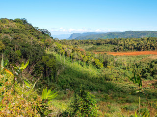 Fototapeta na wymiar Landschaft von Laos in Südostasien mit tropischer Vegetation, Bergen und einer Straße aus rotem Sand