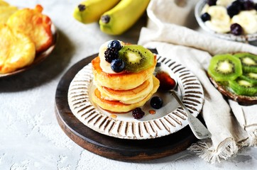 Fritters with honey, banana, blueberries and kiwi, breakfast