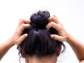 Asian women with dark hair with itchy head and use hand scratching and messy hair. Hair health problems.
