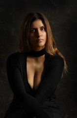 Fototapeta premium Portrait of a lovely young brunette woman in a black dress
