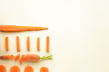 Flat lay composition with ripe carrots on a pastel background with space for text.