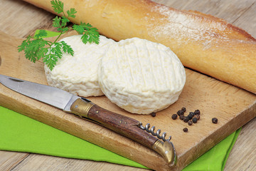 petit fromage de chèvre et baguette de pain sur une table