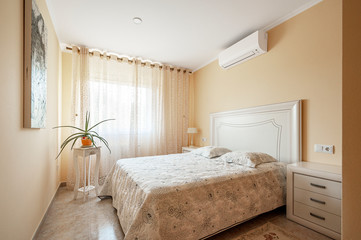 Fototapeta na wymiar Interior of cozy bedroom in modern design with craft floor with air conditioning on the ceiling.