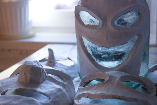 Scary papier mache masks made with your own hands. Handmade paper and dough. Masks for the holiday. Halloween.
