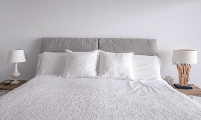 Lacy white pillows on the sleeping bed. Comfortable soft pillows and decorative lamps.