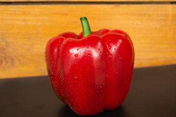 Red juicy bell pepper on a wooden background