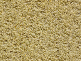 Yellow background facade plaster . Monolithic plaster decorative backdrop. Single layer scraped cement plaster wallpaper. Exterior building structure backdrop. Silica sand cement wall plaster