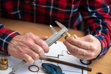 Plumber using a caliper