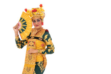 Woman Balinese dancers standing hold a fan beside copyspace, traditional Indonesia dance culture costume