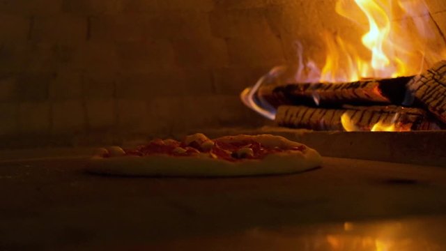 Italian pizza Pepperoni is cooked in the oven, restaurant pizza cooking in a wood fired oven at traditional restaurant.