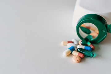 Top view of medicine tablets pour from pills bottle of marble texture white background. Health care medical lifestyle.