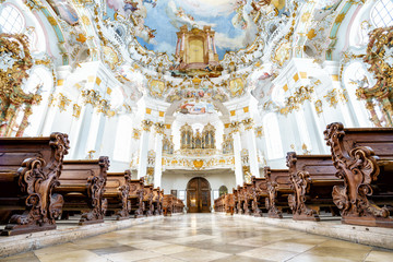 WIESKIRCHE, GERMANY – MARCH 07: View on rococo interior of chapel with benches on March 07, 2016 in Wieskirche, Germany. - obrazy, fototapety, plakaty
