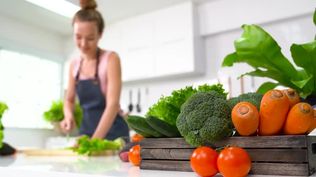 Young woman chopping vegetables in the kitchen , Preparation of vegetables for the salad .