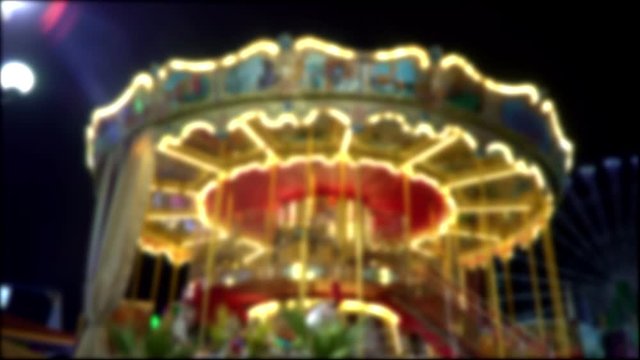 Blurred carousel in city park at night.