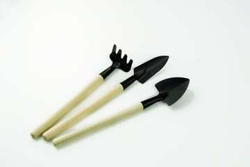 garden tool shovel, scoop, iron rake with wooden handles on a white background.