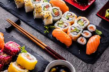 apanese sushi food. Maki ands rolls with tuna, salmon, shrimp, crab and avocado. Top view of assorted sushi. Rainbow sushi roll, uramaki, hosomaki and nigiri