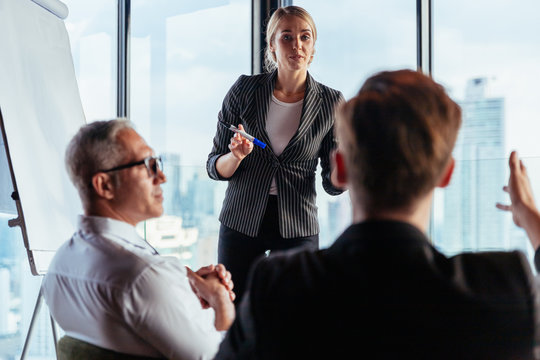 Businesswoman coach speaker wear suit give blank flipchart presentation, Speaker presenter consulting training persuading employees client group, Business meeting, seminar, presentation concept.