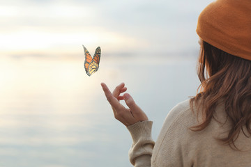 colorful butterfly is laying on a woman's hand - 329289857