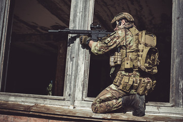 Two men in military camouflage vegetato uniforms with automatic assault rifles