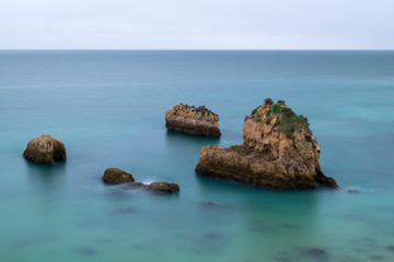 Tranquil scene of the rocks in the acean at the beautiful Ponta Joao de Arens in Portimao, Algarve, Portugal