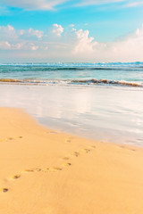 Tropical sea shore. Blue sky, wavy ocean and sandy beach. Warm evening sunlight toned. Sri-Lanka island.
