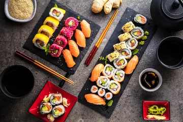 Fotobehang apanese sushi food. Maki ands rolls with tuna, salmon, shrimp, crab and avocado. Top view of assorted sushi. Rainbow sushi roll, uramaki, hosomaki and nigiri © karepa