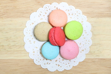 Closeup top view of colorful macarons stack like flower on wood background. Flat lay style.